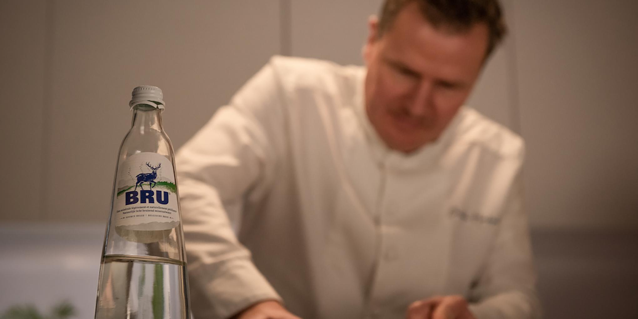 Christophe Hardiquest in de keuken van zijn restaurant Bon-bon met een fles van BRU®