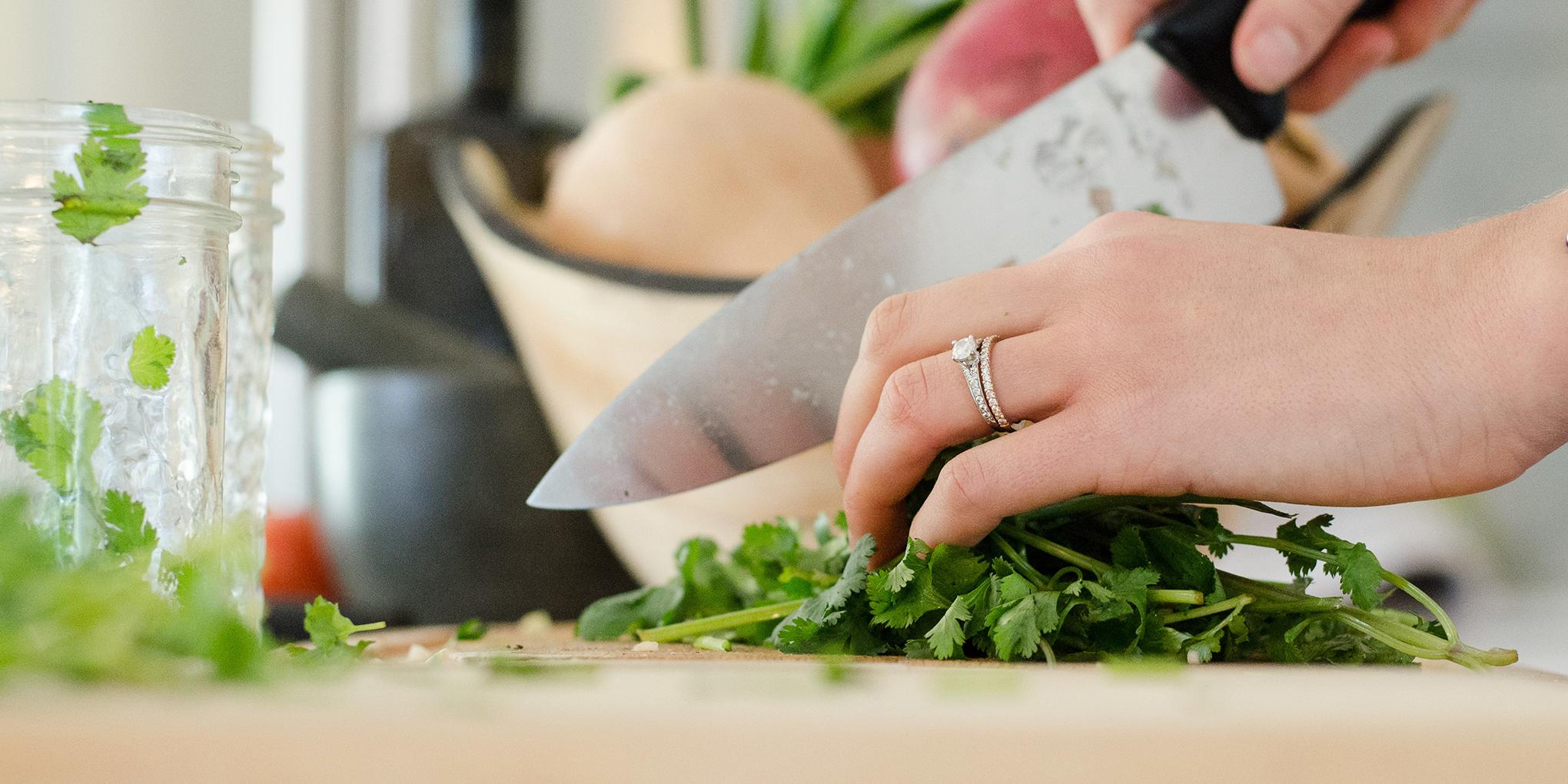 Werkblad met handen die groenten snijden